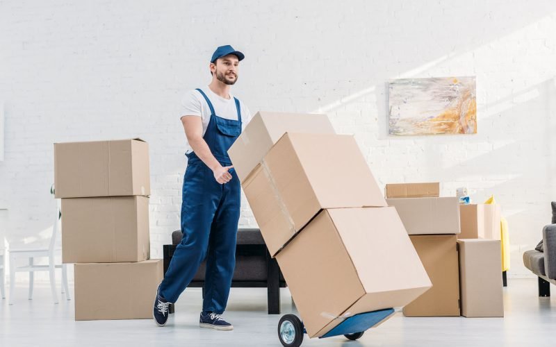 mover-in-uniform-transporting-cardboard-boxes-on-X6KAQDN-rb5ceg9k1vh3br47x0st7wqmkud93e4ja7agbkffd4